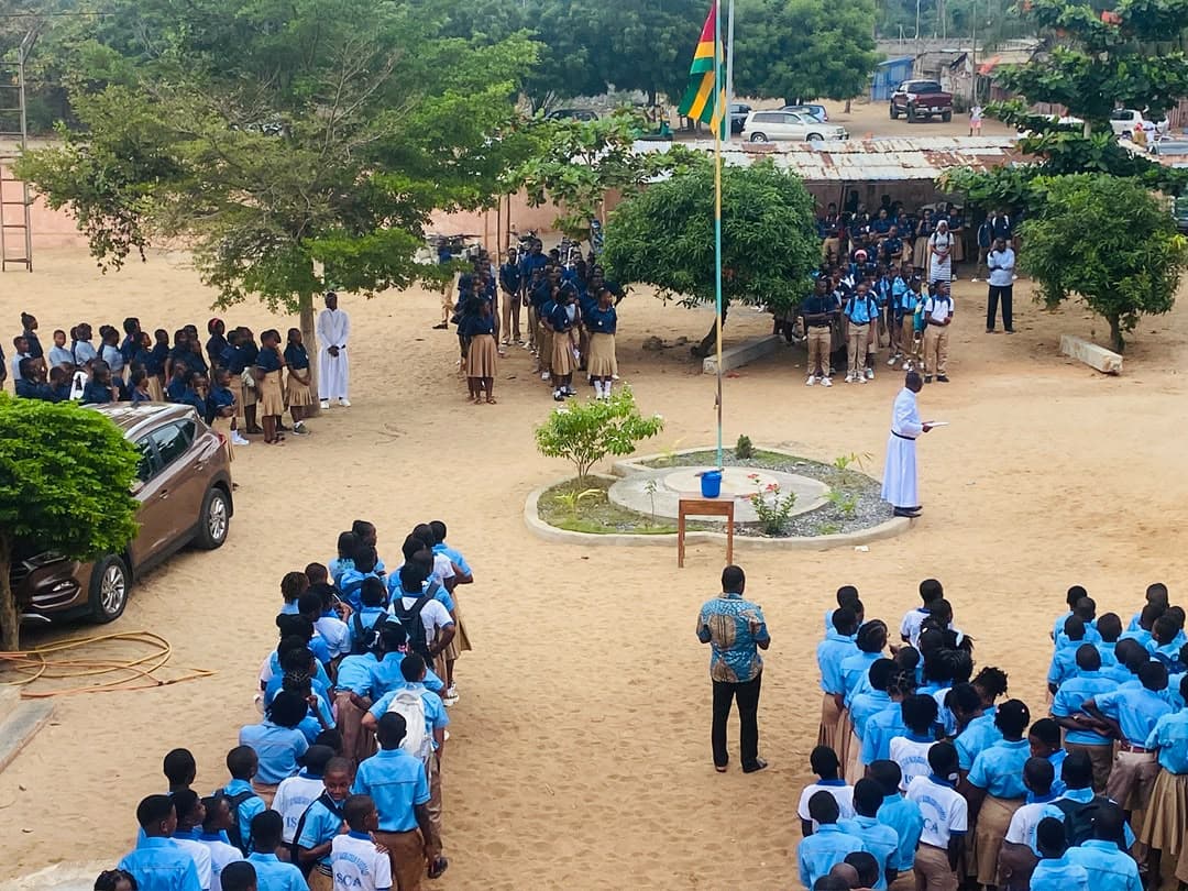Les élèves rassemblés autour du drapeau togolais dans la cour